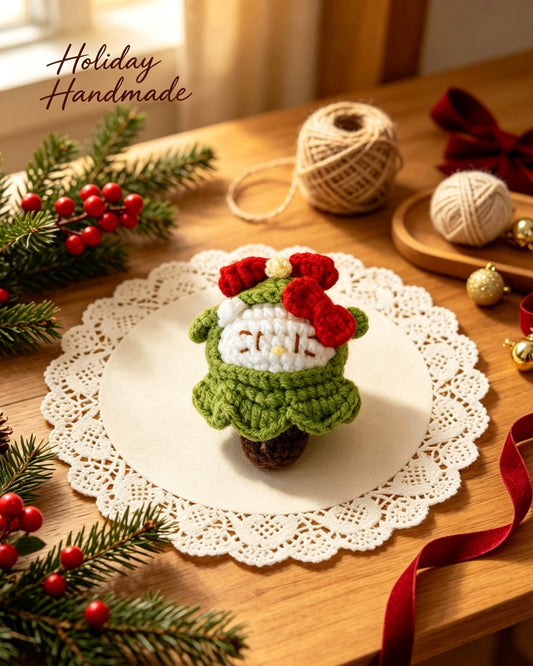 Christmas Tree Kitty crochet plush on a lace doily with holiday decor