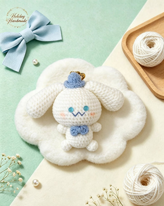 Handmade crochet puppy keychain with a blue mini hat and bow tie, styled scene with yarn ball